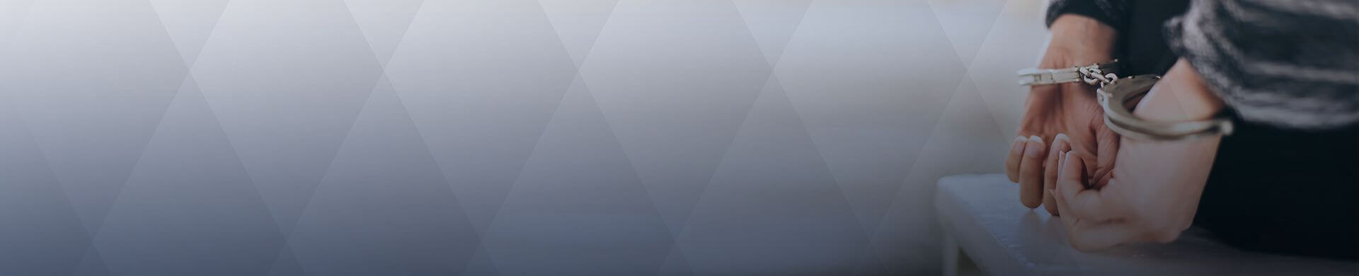 Focus on hands in cuffs behind a person's back